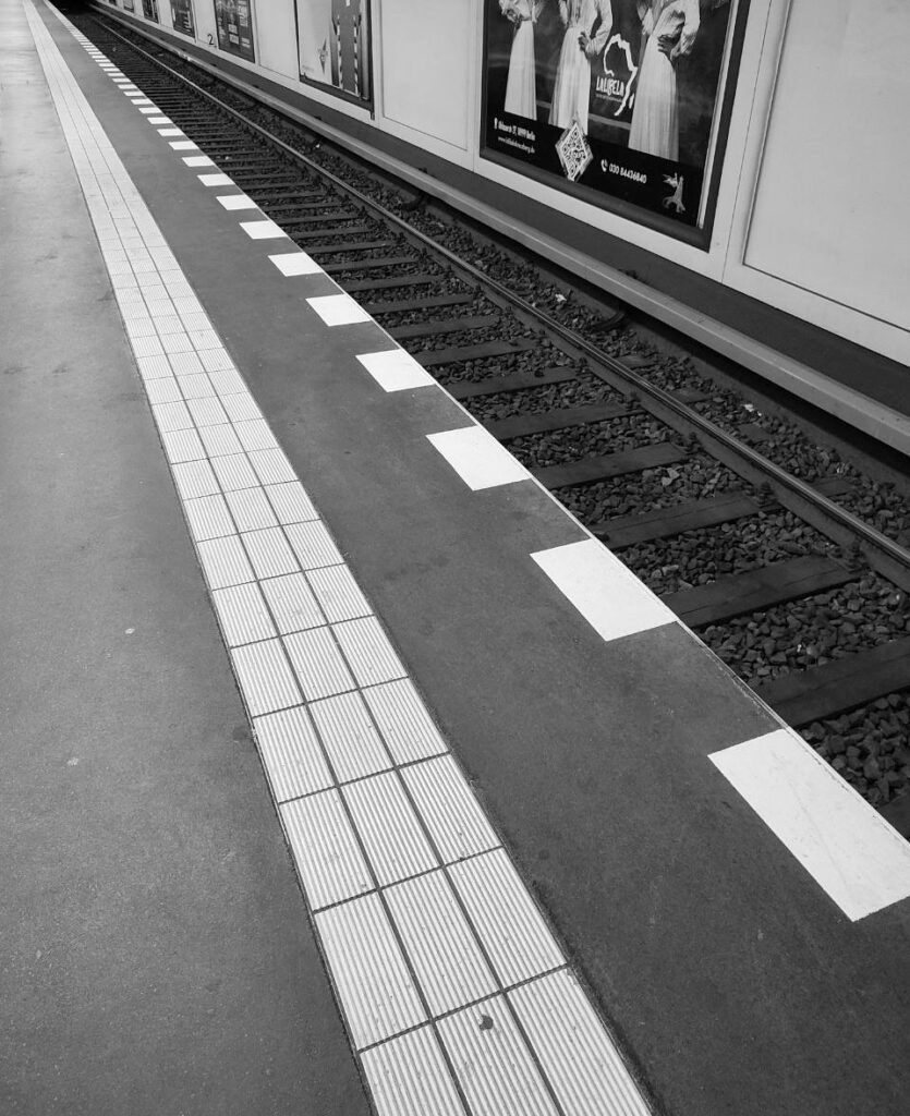 Black and white image of Berlin U-Bahn station with vanishing point in corner.